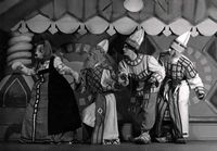 Noorsooteater: ā€Kassimajaā€¯ (S. MarÄ‘ak, 1947). Stseen lavastusest (1): (vasakult) V. Karusoo (Kass Liisu), R. Kuremaa, F. Veike, L. Rost.